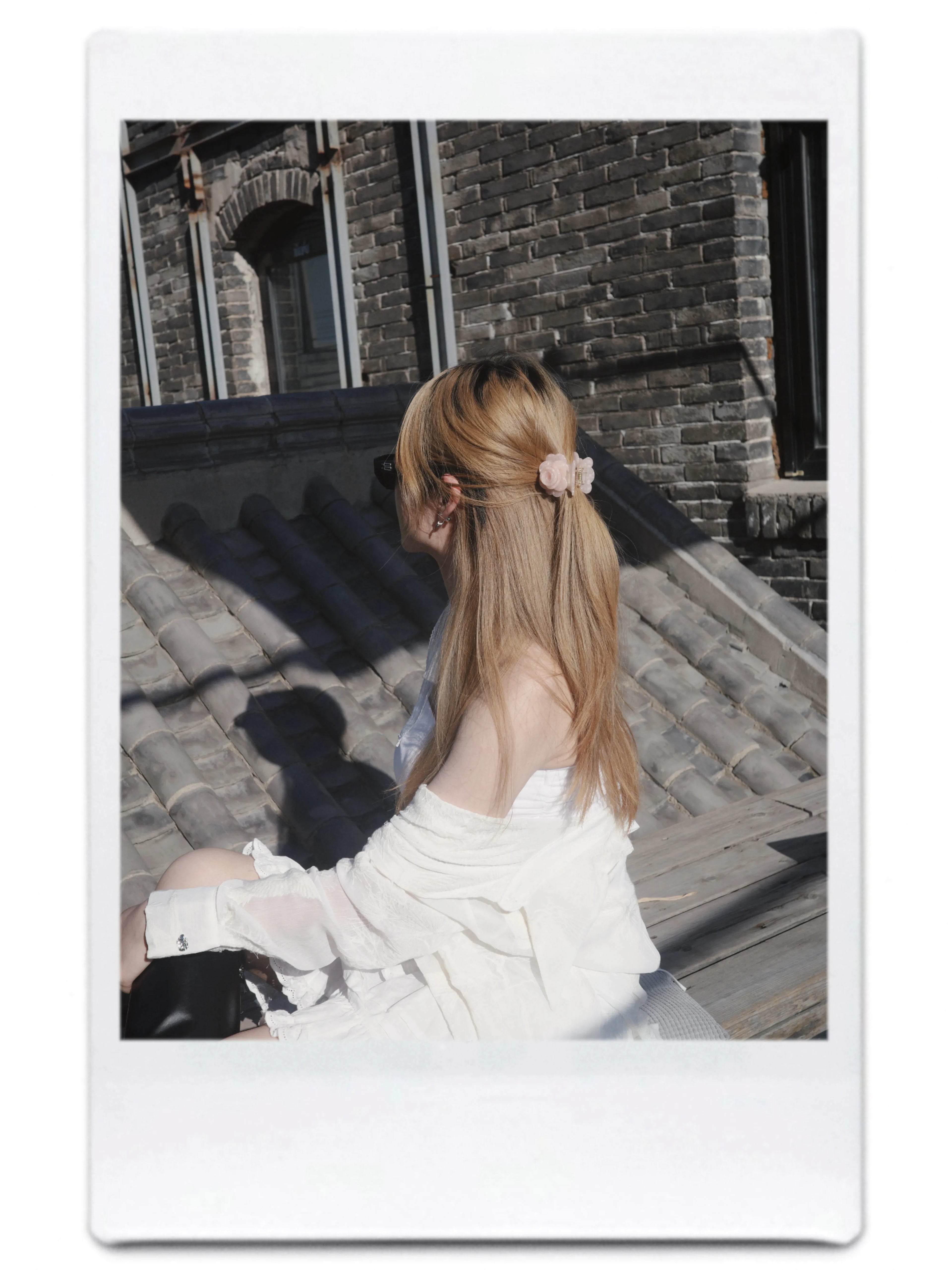 Girl wearing Petit Rose Claw in pink while sitting outdoors – soft and dreamy hair accessory look.