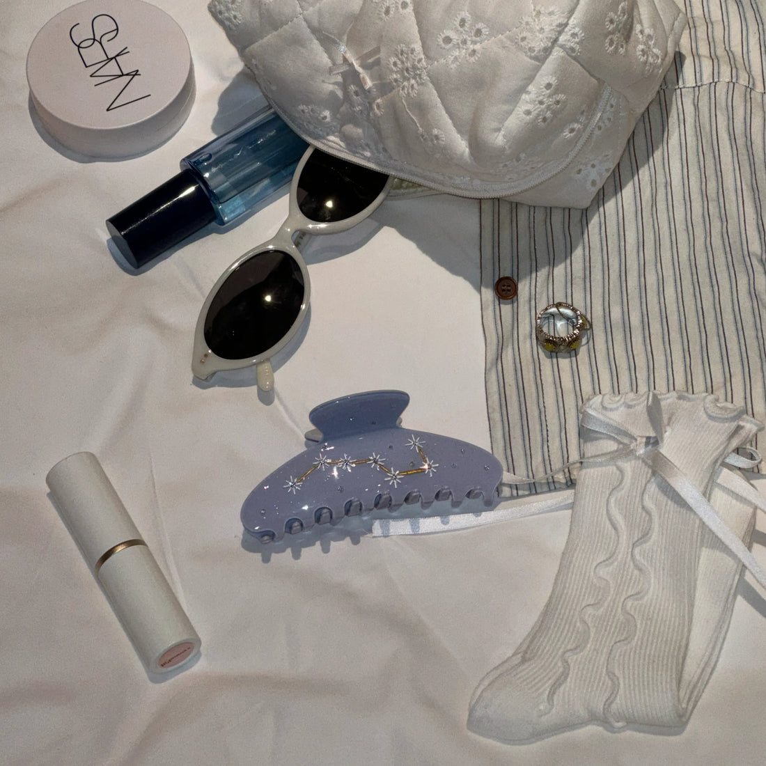 Flatlay of Irisa Rosa lavender claw clip styled with chic daily essentials – perfect for quick 5-minute hairstyles.