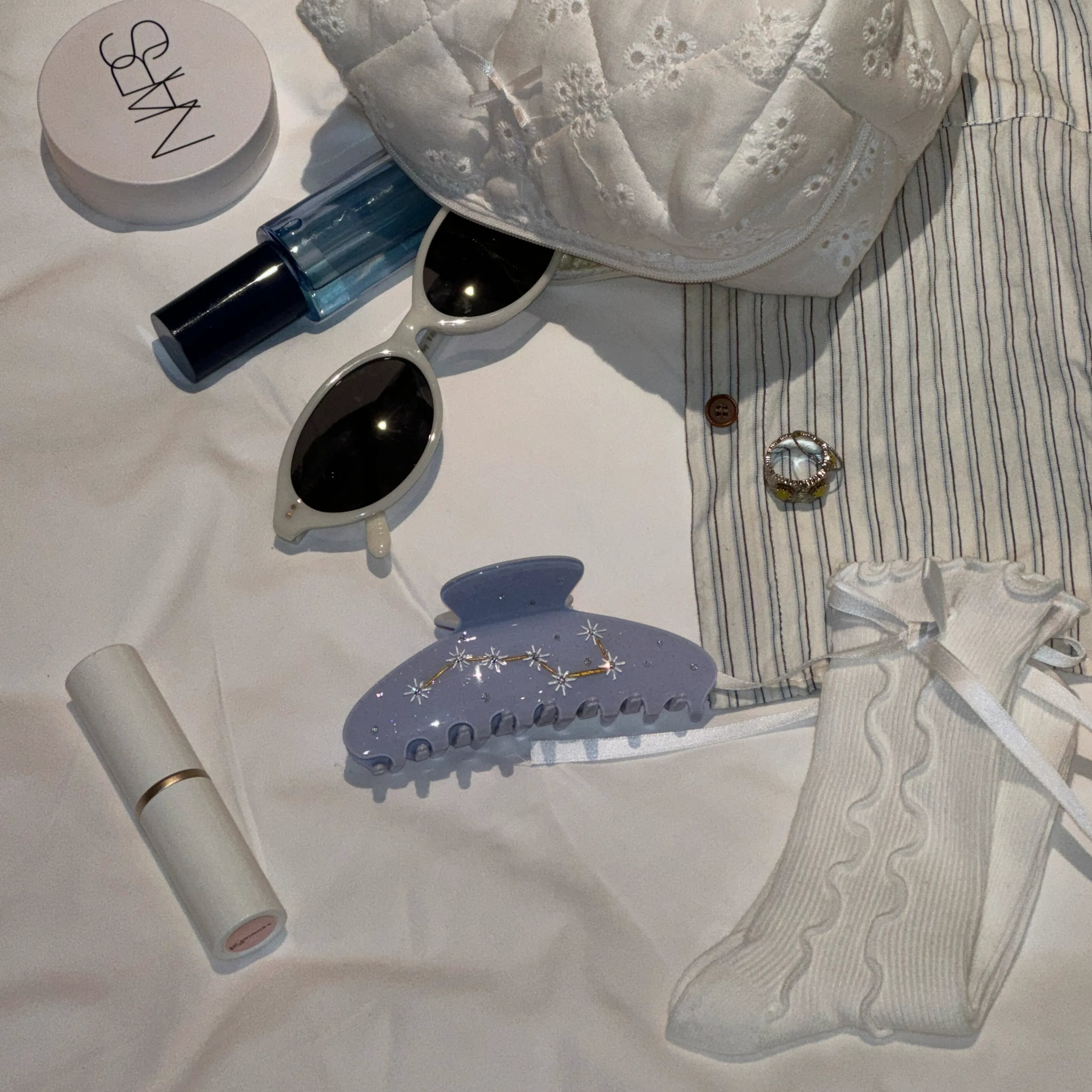 Flatlay of Irisa Rosa lavender claw clip styled with chic daily essentials – perfect for quick 5-minute hairstyles.