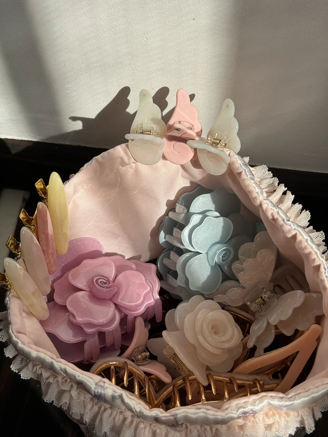 Collection of pastel flower-shaped sustainable hair claw clips in a soft fabric pouch – eco-friendly and stylish choice for modern women.
