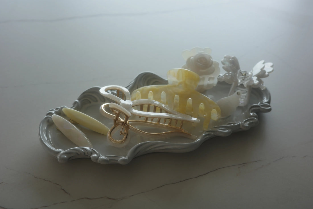 A collection of pastel and floral hair clips neatly arranged on a decorative tray, symbolizing hair accessory care and organization.