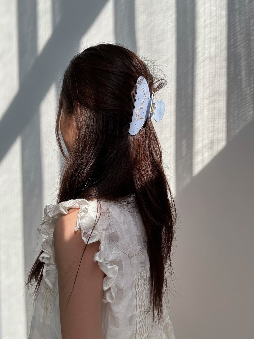 Lifestyle portrait – model styling with Blue Big Dipper Hair Claw in natural light