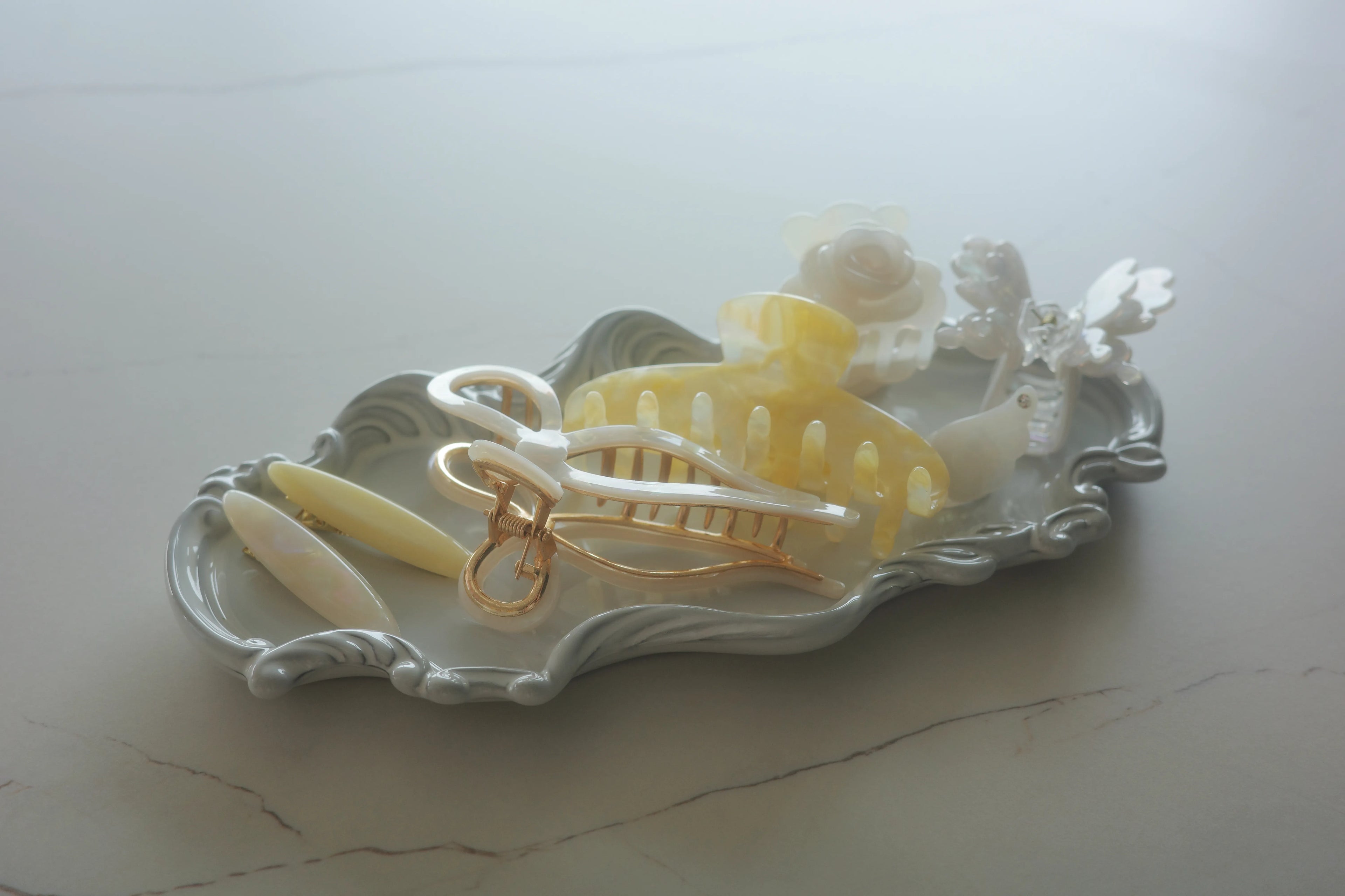 Irisa Rosa Gabrielle Claw new arrivals – elegant yellow and white acetate hair claw clips displayed on tray