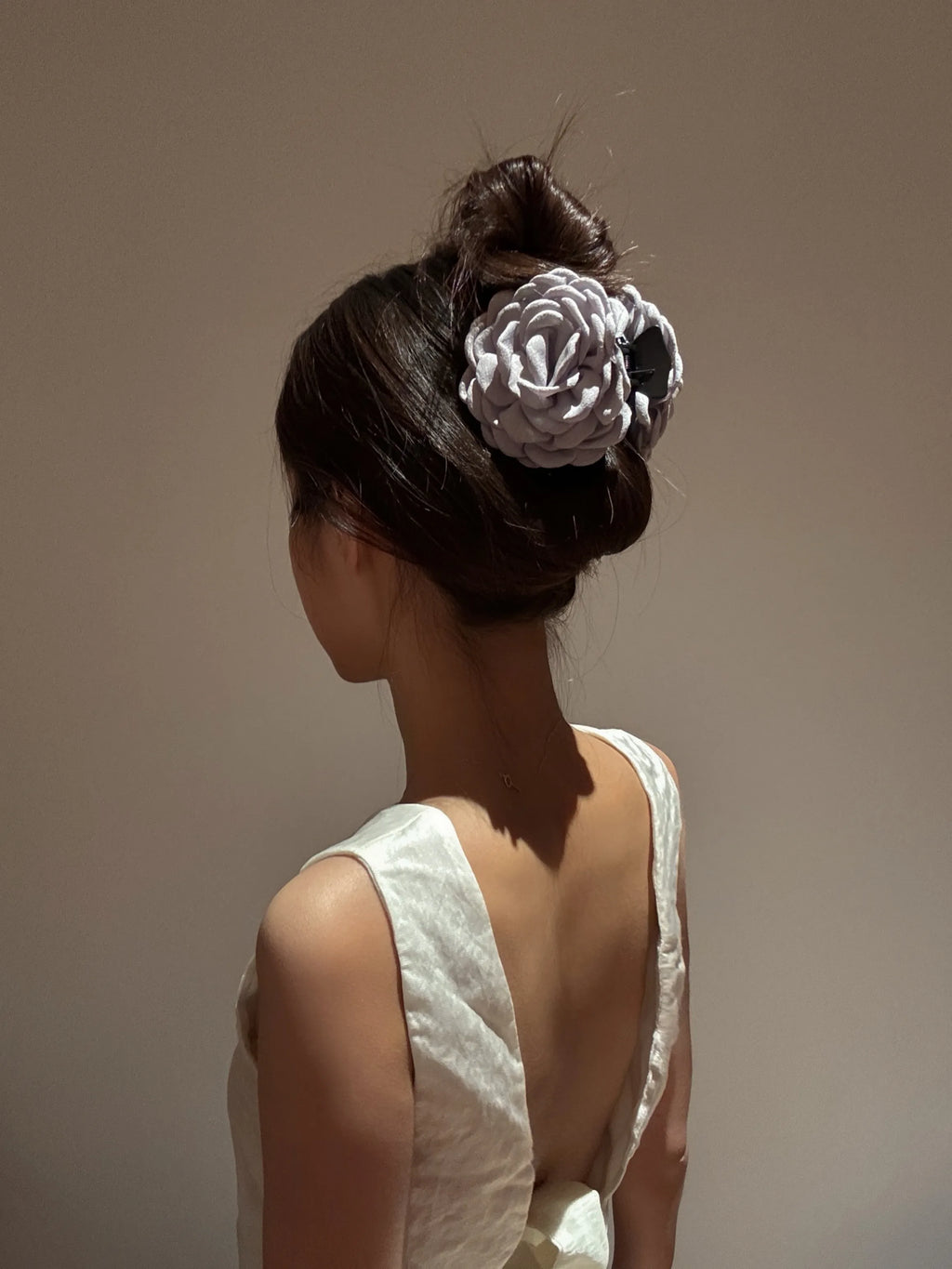 Model styling with grey Camellia Hair Claw – chic floral hair accessory for daily and wedding looks